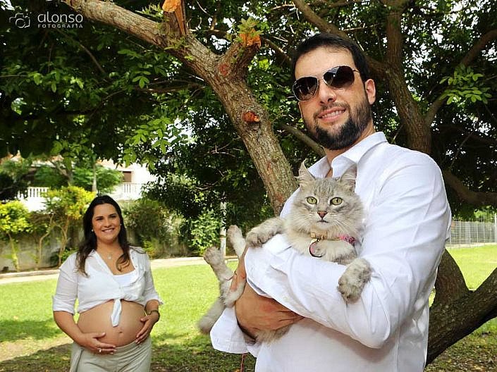 casal segurando gata em ensaio de gestante