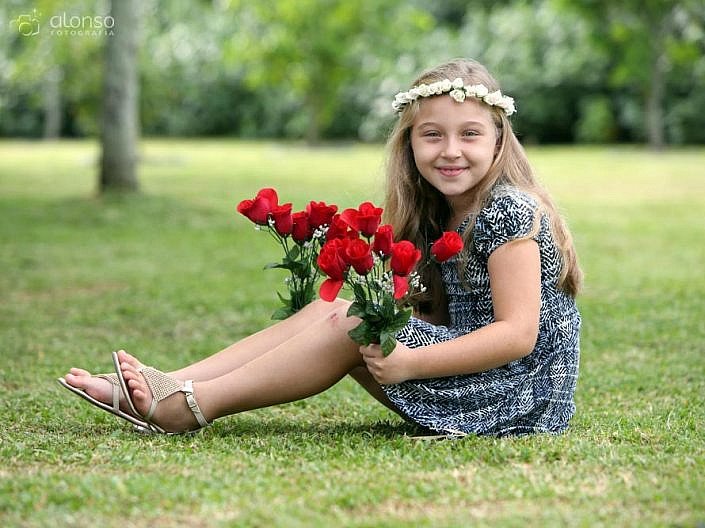 Menina na grama com rosas vermelhas book